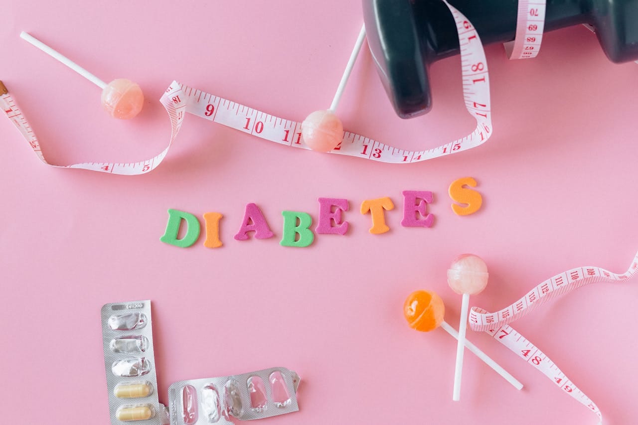 Creative flat lay display of diabetes-related items with a pink backdrop. Ideal for health-related concepts.